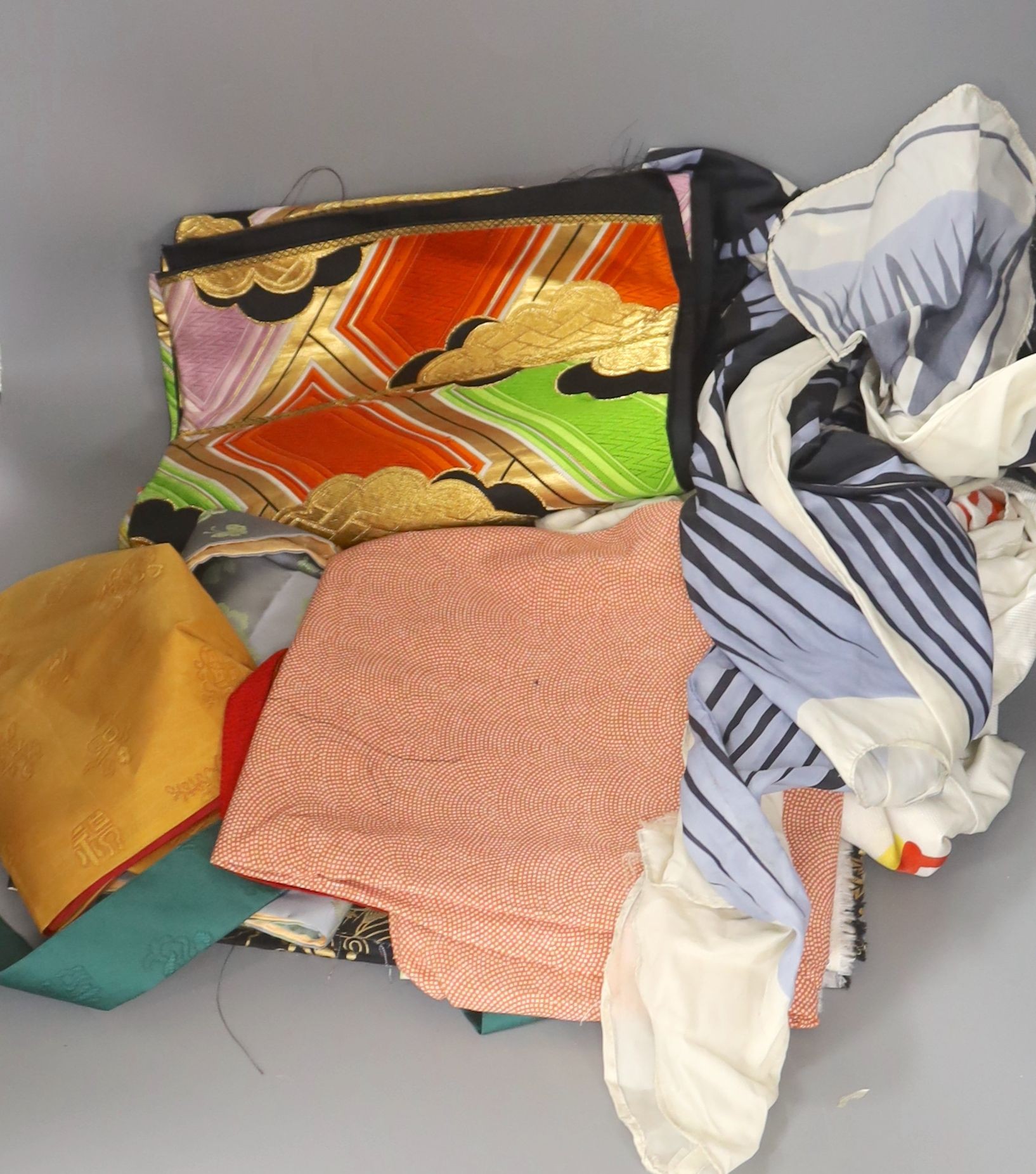Two Japanese kite flags and various obi's and textiles